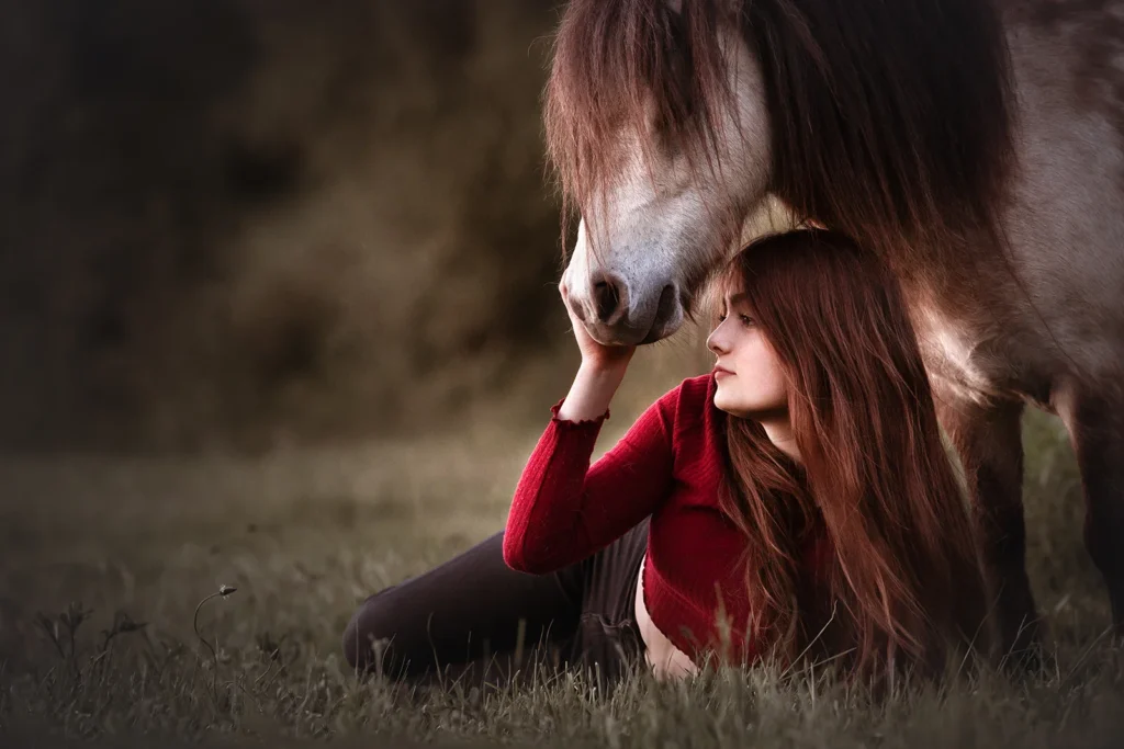 Inniges Kuschel Foto von einem Shetland Pony und einer jungen Frau, sehr ausdrucksstark und naturnah, aufgenommen auf einer Weide im Ruhrgebiet (NRW) durch die Pferdefotografin Anne Bertling aus Ascheberg bei Münster im Münsterland.